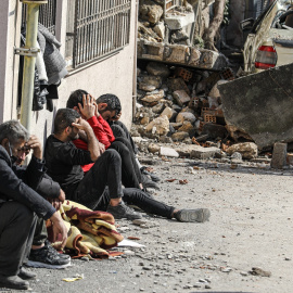 Varias personas lloran la muerte de sus seres queridos tras el devastador terremoto y sus réplicas a lo largo de la frontera turco-siria el pasado febrero.