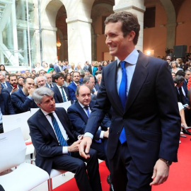 02/05/2019.- El presidente del PP, Pablo Casado (d), pasa por delante del expresidente de la Comunidad de Madrid, Angel Garrido (sentado-2i), a su llegada a los actos conmemorativos de la festividad del Dos de Mayo, Día de la Comunidad de M