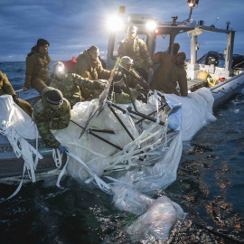 Fotografía cedida por la Armada de Estados Unidos donde aparecen unos marineros mientras recuperan el globo de vigilancia chino del mar.