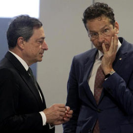 El presidente del Banco Central Europeo, Mario Draghi, habla con el presidente del Eurogrupo, Jeroen Dijsselbloem, durante la reunión del Ecofin en Riga. / VALDA KALNINA (EFE)