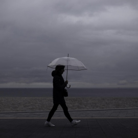 Una mujer caminaba este viernes por el paseo marítimo de A Coruña el 8 de abril de 2022