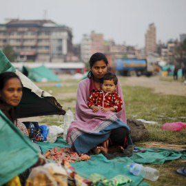 Una víctima del terremoto lleva en brazos a su hermana fuera de su refugio improvisado en las afueras de Katmandú, Nepal./ REUTERS/Adnan Abidi