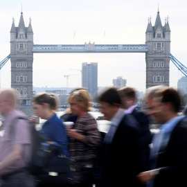 Trabajadores cruzan junto al Puente de Londres, en la hora punta por la mañana. REUTERS/Toby Melville