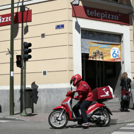 Un repartidor de Telepizza, con su moto, en un establecimiento de Madrid. REUTERS