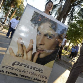 Una fan del fallecido músico estadounidense Prince sostiene un cartel con su imagen. EFE/MIKE NELSON