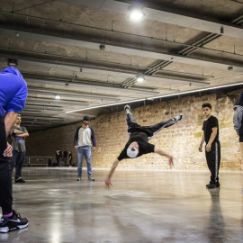 Un grupo de jóvenes hace 'break dance' al lado de la muralla de Barcelona.