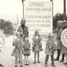 Ciudadanos daneses que fueron al pueblo de Huéscar (Granada) a la "firma del tratado" de paz con su país, con el lema de "amistad hispano-danesa", escrito en su idioma, en los escudos.