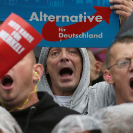 Simpatizantes de Alternativa para Alemania (AfD) gritan durante un acto de campaña de la canciller alemana Angela Merkel el 6 de septiembre del 2017. REUTERS/ Reinhard Krause