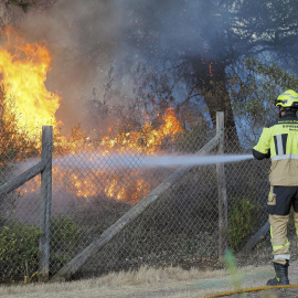 Un bombero intenta apagar el incendio forestal en el paraje natural de la Laguna de El Portil, en el término municipal de Punta Umbría (Huelva) el 26 de abril de 2023.