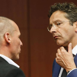 El ministro de Finanzas griego, Yanis Varoufakis, conversa con el presidente del Eurogrupo, Jeroen Dijsselbloem, que cruza los dedos, durante la reunión los ministros de Economía y Finanzas de la Unión Europea en Bruselas (Bélgica). / EFE