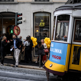 Varios viandantes aguardan el paso del tranvía en Lisboa el 20 de noviembre de 2021.