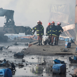 Los bomberos evacúan la zona del incendio en Bangladesh.