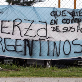 Un hombre pasa ante una bandera argentina colocada en la base naval de Mar del Plata. | REUTERS