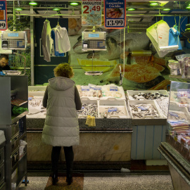 Una mujer compra en una pescadería en un mercado, a 15 de marzo de 2023, en Madrid.