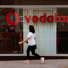 Una mujer pasa por delante de una tienda de Vodafone en Ronda (Málaga). REUTERS/Jon Nazca