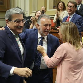 2/07/2019.- Los portavoces de los grupos de Nueva Canarias, Román Rodríguez (i), y de Si Podemos Canarias, Noemí Santana (2d), felicitan al socialista Ángel Víctor Torres (c), tras ser elegido presidente de Canarias, con el respaldo del PSO