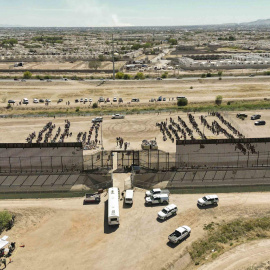 Fotografía aérea muestra hoy a cientos de migrantes mientras esperan junto al muro fronterizo en El Paso, Texas (EE.UU)