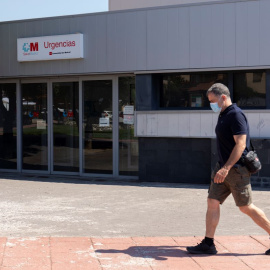 Un hombre pasea con mascarilla, frente a la entrada de urgencias del ambulatorio de Moralzarzal, a 26 de junio de 2021, en Madrid.