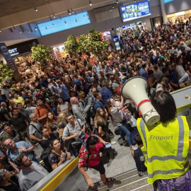 Personal del aeropuerto informa a pasajeros y visitantes mientras esperan a que se termine la evacuación en el aeropuerto de Fráncfort (Alemania), hoy, 7 de agosto de 2018. La evacuación preventiva de una parte de la Terminal 1 del aeropuer