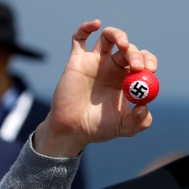 Un manifestante sostiene una pelota de golf con una esvástica dibujada en una rueda de prensa del candidato presidencial republicano Donald Trump en Turnberry Campo de golf en Turnberry , Escocia.- REUTERS / Carlo Allegri