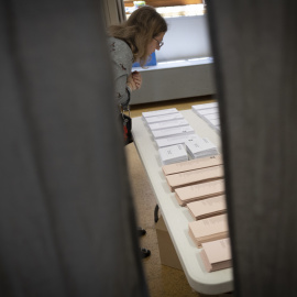 Una mujer observa las papeletas en la jornada electoral del 28M.