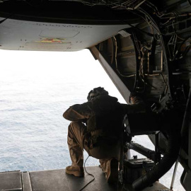 Un marine estadounidense mira desde un avión que vigila las aguas del Golfo de Omán. (AHMED JADALLAH | REUTERS)