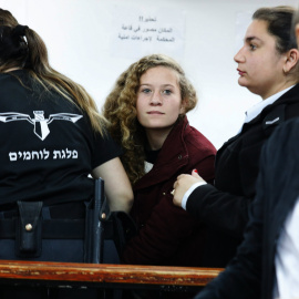 La adolescente palestina  Ahed Tamimi, es escoltada por agentes de la policía israelí hacia un juzgado en la localidad de Betunia (Palestina). EFE/ Abir Sultan