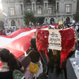 Una manifestante sostiene una bandera de Perú con un mensaje contra el indulto otorgado al expresidente Alberto Fujimori durante la protesta en Lima. | EDUARDO CAVERO (EFE)