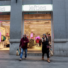 Dos personas salen con varias bolsas de una tienda , a 7 de enero de 2022, en Madrid (España).