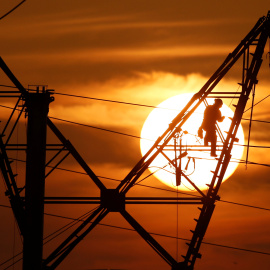 Un operario reparando una torre eléctrica de alta tensión. REUTERS