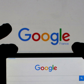 Una mujer sostiene la cámara de su smartphone frente a la portada de Google en Francia. REUTERS/Eric Gaillard