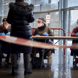 14/02/2021.- Una mujer ejerce su derecho al voto para las elecciones al Parlament, hoy en el polideportivo de Fontajau, de Girona.La participación en las elecciones al Parlament de Cataluña a las 13.00 horas se sitúa en el 22,77 por ciento 