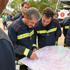 Un equipo de los Bomberos de Barcelona estudian el despliegue de efectivos sobre un plano en un simulacro.