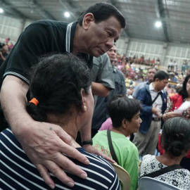 El presidente de Filipinas, Rodrigo Duterte, abraza a una mujer evacuada por un tifón en Filipinas. (EFE)