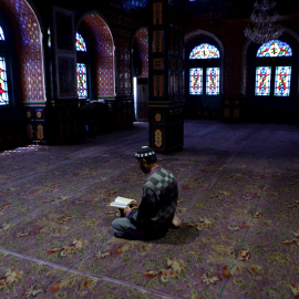 Un musulmán lee el Corán en el interior de una desierta mezquita durante el Ramadán en la ciudad de Srinagar (India). /EFE