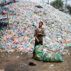 Un trabajador recoge botellas de plástico en una de las plantas de reciclaje de China. FRED DUFOUR / AFP