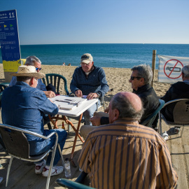 04/0/2023 - Unos hombres juegan al dominó en la playa de la Barceloneta, en Barcelona, Catalunya.