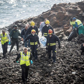 Efectivos de los servicios de Emergencias trasladan el cuerpo de uno de los fallecidos en la playa Bastián de Costa Teguise, donde seis inmigrantes magrebíes han perdido la vida y otros dos se encuentran en estado crítico tras encallar este