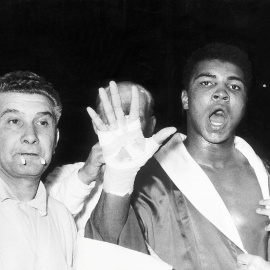 Cassius Clay muestra su mano abierta para predecir que ganará en el quinto asalto en su combate contra Henry Cooper, en el estado de Wembley , en Londres, el 18 de junio de 1963. REUTERS