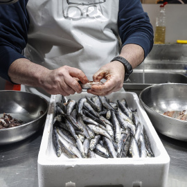 Un vendedor limpia pescado en un puesto de pescado en el Mercado Central de Valencia, a 24 de marzo de 2022, en Valencia, Comunidad Valenciana, (España).