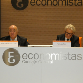 El vicepresidente del BCE, Luis de Guindos (i), junto al presidente del Consejo General de Economistas de España (CGE), Valentín Pich (d), durante un evento informativo de los economistas, en Madrid.  EFE