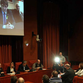 Los diputados electos Carles Puigdemont (c), Clara Pontasí (i) y Lluís Puig (d), participaron telemáticamente desde Bruselas en la reunión celebrada el martes en el Parlament por el grupo parlamentario de Junts per Catalunya. EFE/Toni Albir