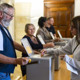 Una mujer deposita su voto en Delemont durante las elecciones federales suizas.