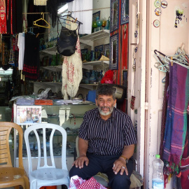 Abu Muhammad sentado en la puerta de su comercio  - Leire Regadas Julio 2019