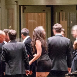 Fotografía del 'Financial Times' en la que se puede ver a una de las jóvenes contratadas junto a varios invitados en la puerta del hotel donde se celebró la cena machista en Londres. FT/Tolga Akmen