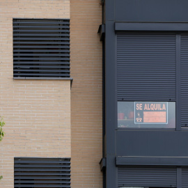 En la fachada de un edificio se ve un cartel de 'Se Alquila' bajo la persiana de uno de los pisos./ Jesús Hellín Europa Press