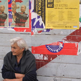 Una mujer descansa junto a carteles de propaganda electoral