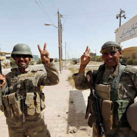 Soldados iraquíes saludan en el centro de Faluya, Irak. REUTERS/Thaier Al-Sudani