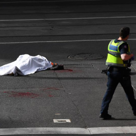 09/11/2018.- El cadáver de una víctima yace sobre el asfalto después de que un hombre armado con un cuchillo atacase a varias personas en la calle Bourke de Melbourne (Australia), hoy, 9 de noviembre de 2018. Una persona murió y otras dos s