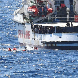 Varios migrantes saltan por la borda del Open Arms para llegar a nado a la isla italiana de Lapedusa, desesperados tas 19 días encerrados en el barco español.- REUTERS